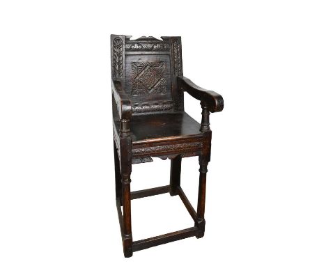 17th century child's high chair, with carved panelled back and solid seat on slightly splayed gun barrel legs united by stret