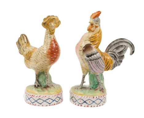 Unusual pair of Staffordshire pottery models of a cockerel and a hen, circa 1860, shown standing on round patterned bases, 17