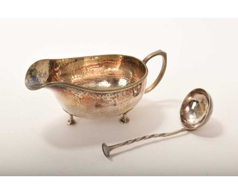 1920s silver sauceboat of conventional form, with spot hammered finish and loop handle, on three disc feet, together with a m