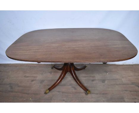 Regency mahogany breakfast table, with rounded rectangular tilt-top on splayed quadruped supports and brass cappings and cast