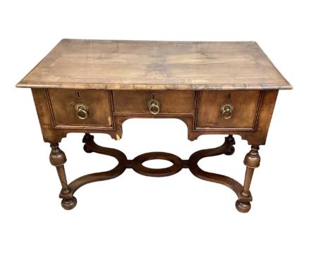 Queen Anne style walnut crossbanded kneehole writing table, with three drawers on cup and cover supports united by shaped str