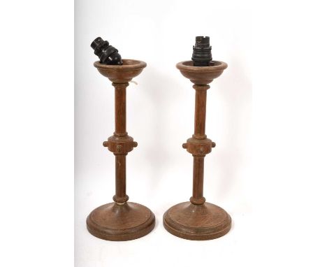 Pair of early 20th century Arts and Crafts style oak table lamps, the stems with beaded knots, on weighted circular bases, 33