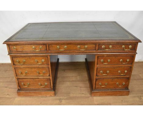 Large antique oak pedestal desk, with tooled leather inset top and nine drawers about the kneehole on plinth bases, 143cm wid