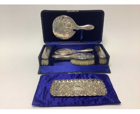 Edwardian silver five piece dressing table set with embossed foliate scroll decoration, in fitted case (Chester 1906), togeth