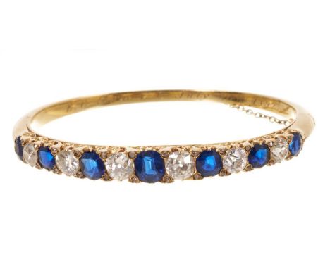 Fine Victorian sapphire and diamond hinged bangle with a row of graduated oval mixed cut blue sapphires alternating with grad