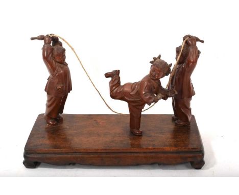 Chinese Cultural Revolution carved wood group of skipping children, raised on integral plinth base, 30cm wide Repairs to the 