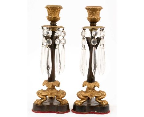 Pair of Regency ormolu and bronze mounted candlesticks, with glass prismatic drops and raised on lion paw feet and shaped bas