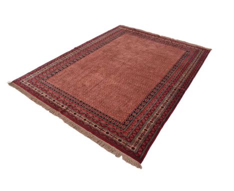 Indian hand knotted woolen carpet with geometric pattern on red ground, 244cm x 316cm, recently professionally cleaned at a c