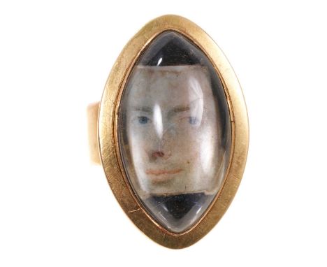 Georgian portrait ring with a portrait miniaure of a gentlemen's face under a domed crystal in oval gold mount with locket co