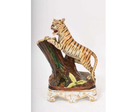 Paris porcelain spill vase, circa 1860, in the form of a tiger climbing a tree, on a scrolled gilt base, 18cm high