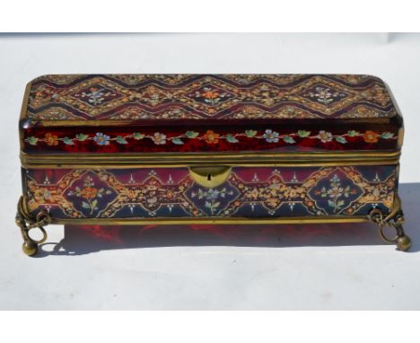 A 19th century Bohemian ruby glass casket with enamelled and gilt decoration, on scrolling brass feet, 32 cm wide Condition R