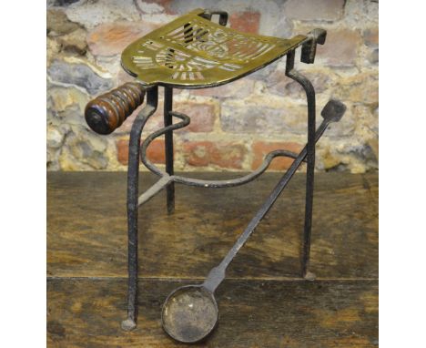 A pierced brass and wrought iron footman to/w a wrought iron metal-smelting ladle (2) 