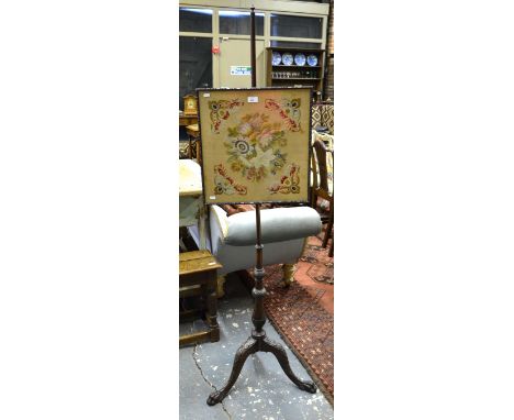 A Victorian mahogany pole tripod pole screen with needlepoint rise and fall panel under glass, raised on carved paw foot supp