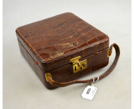 A 1920s good quality crocodile leather vanity case with easel mirror, four silver topped bottles, London 1925 and two ivory h