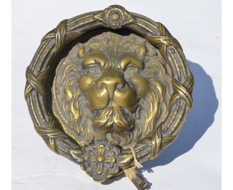 A large and heavy cast brass door knocker with lion mask and ring, 23 cm diameter