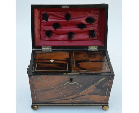 A Regency period brass inlaid coromandel tea caddy, the interior with two lidded compartments, raised on brass ball feet Cond