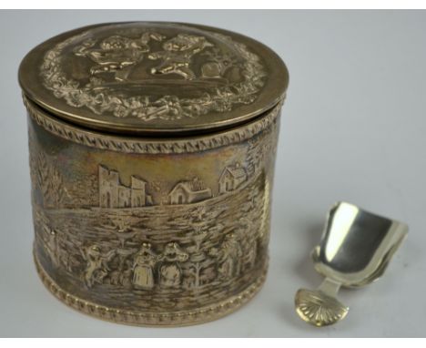 A late Victorian oval silver tea caddy with hinged cover, richly embossed and chased in the Continental manner with figures i