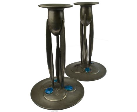 A pair of Archibald Knox design Liberty Tudric Art Nouveau pewter candlesticks of organic form with three twisted fin stems a