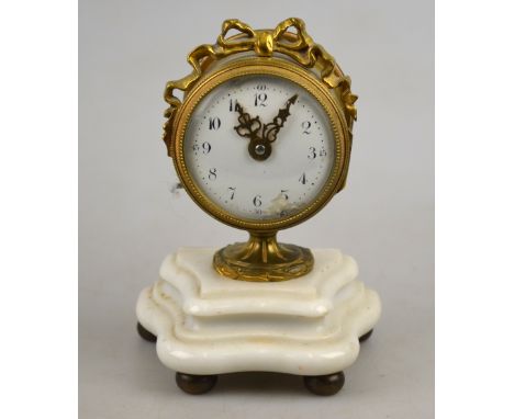 A small French brass drum timepiece with ribbon decoration, enamel dial and Swiss lever movement, on stemmed foot and moulded