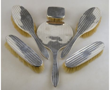 An engine-turned silver five-piece brush set, Birmingham 1922, to/w a small silver-backed brush, Birmingham 1927 (6) (box)