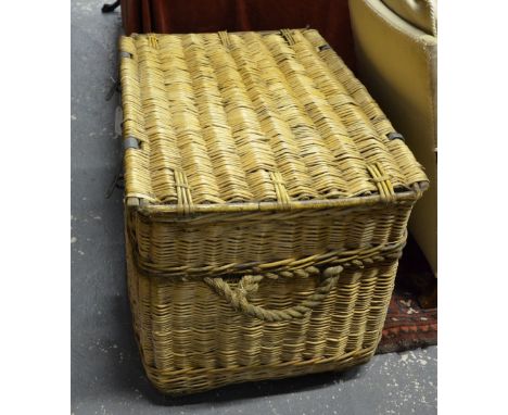 A large vintage wicker linen basket with steel strap handles