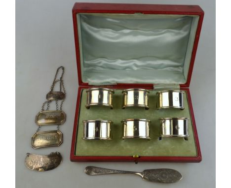 A red morocco-cased set of six numbered napkin rings, George Unite, Birmingham 1921, to/w a Georgian 'Brandy' decanter label,