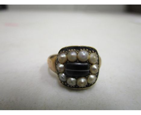 A Victorian mourning ring with yellow coloured shank, central agate stone, surrounded by pearls, inscription to underside rea