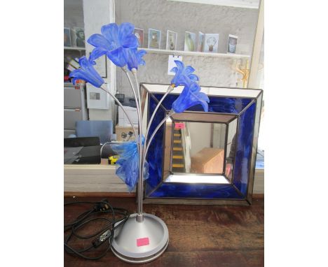 A contemporary silver coloured table lamp with four swirled blue glass flower head shaped shades, and one shade spare, and bl