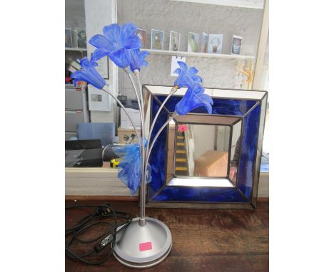 A contemporary silver coloured table lamp with four swirled blue glass flower head shaped shades, and one shade spare, and bl