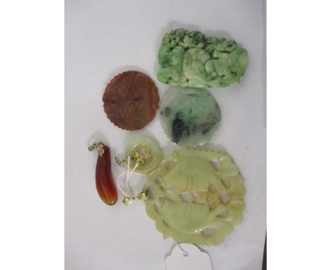 A jade circular pendant and companion, both with yellow metal mounts and four further pendants, two decorated with carp 