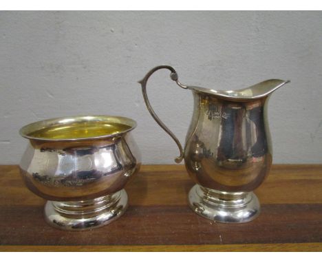 An Elizabeth II silver cream jug and sugar bowl of baluster form, on spreading circular feet and gilded interiors, Birmingham