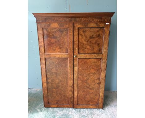 Victorian figured walnut wardrobe with a moulded cornice over a pair of panelled doors enclosing hanging rails, on a plinth b