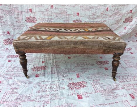 Kelim covered stool with turned beech legs & brass castors, 82x66cm