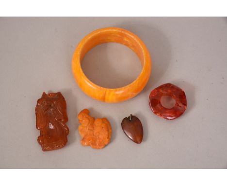 Four Chinese amber carvings and a bangle.