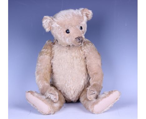 A wood straw-filled mohair humpback teddy bear with swivel head, probably Steiff, with boot button eyes, stitched snout and c
