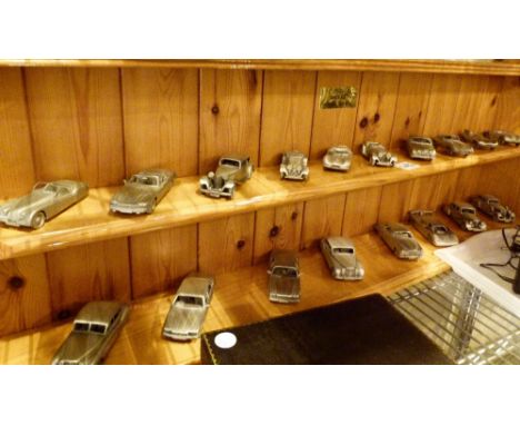 Eighteen Mint Dinky pewter model Jaguar cars, with pine display shelf, RRP £40 each
