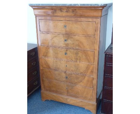 An early 19th Century light flame mahogany veneered Continental marble topped Samainier, six full width drawers above shaped 