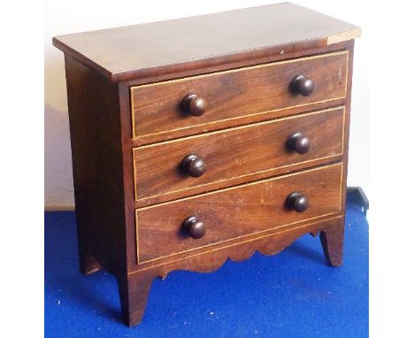 An early 19th century mahogany Apprentice Chest, the overhanging top above three full-width graduated drawers with turned han