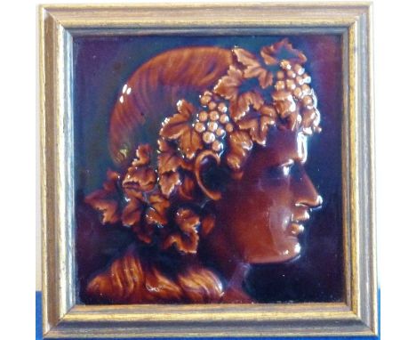 An interesting late-19th/early-20th century framed Hearthstone depicting a brown glazed profile of Bacchus, the tile marked '