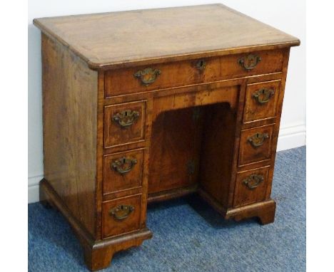 A fine early 18th Century figured walnut Kneehole Desk of pleasing proportions, the quarter veneered banded and crossbanded m