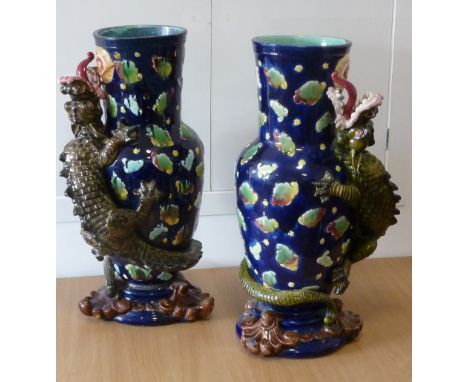 ADDED LOT    A large pair of 19th century Majolica Vases, each decorated in high relief with a dragon chasing a flaming pearl