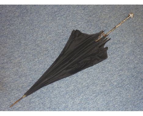 An early 20th century Parasol having a hand-chased white metal (marked sterling) long handle decorated with flowers etc. in t