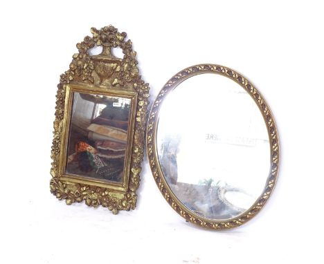 An oval gilt-framed wall/toilet mirror, with strut, and an Antique giltwood wall mirror, with swag and urn mount 