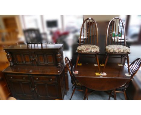 An Ercol dark stained elm dining suite, comprising circular drop-leaf table, 114cm diameter, set of four high stick-back chai