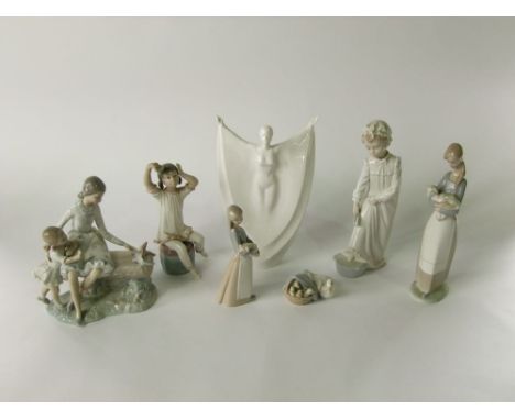 A collection of Lladro and Nao figure groups comprising two girls feeding doves, girls holding a lamb and a piglet, a child s