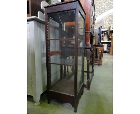 An Edwardian mahogany freestanding vitrine of square cut form with shallow moulded top over a glazed panelled surround with s