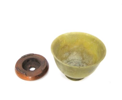 A simple turned jade bowl on a hardwood stand, 9 cm diameter 6 cm high