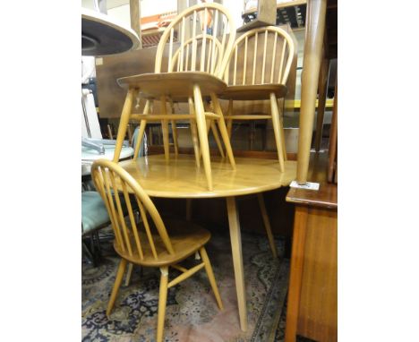 Ercol light elm drop leaf dining table together with a set of four Windsor chairs