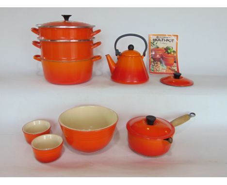 A collection of Le Crueset cookware to include three tier steamer, lidded saucepan, enamel kettle, a pudding bowl and two ram