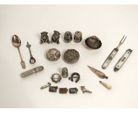 A mixture of small silver and other vitrine objects including two silver teddy bear peppers, travelling fork, brooches, etc